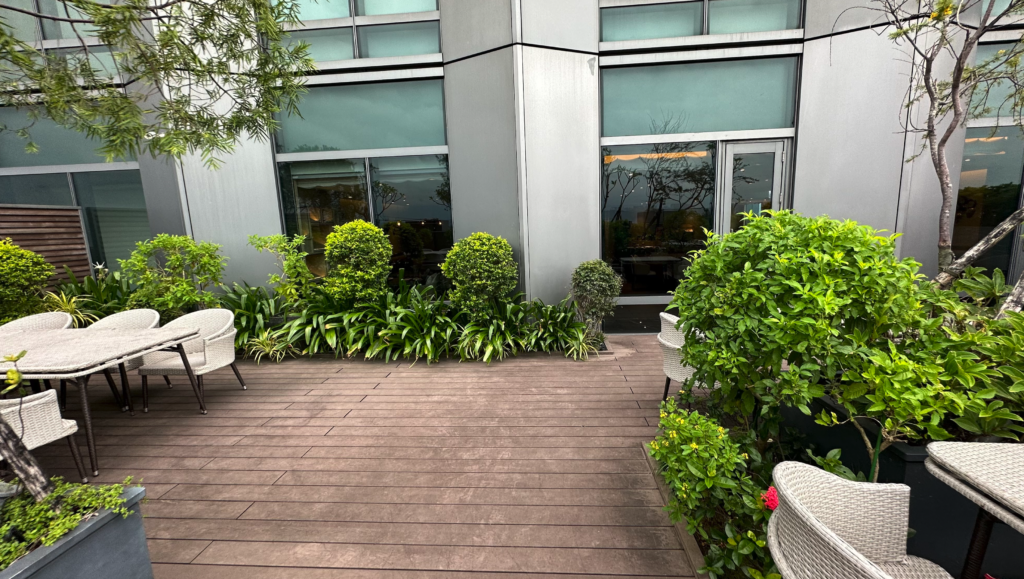 a patio with plants and chairs