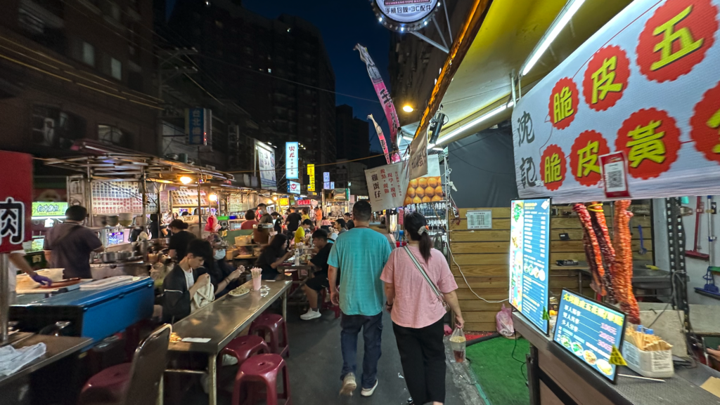 people walking down a street with tables and food