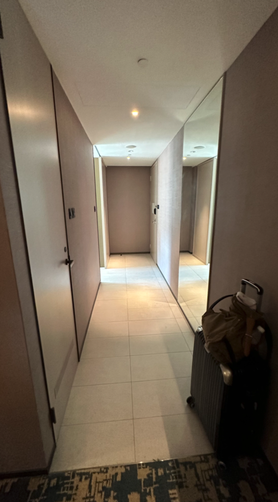 a hallway with a luggage bag and a mirror