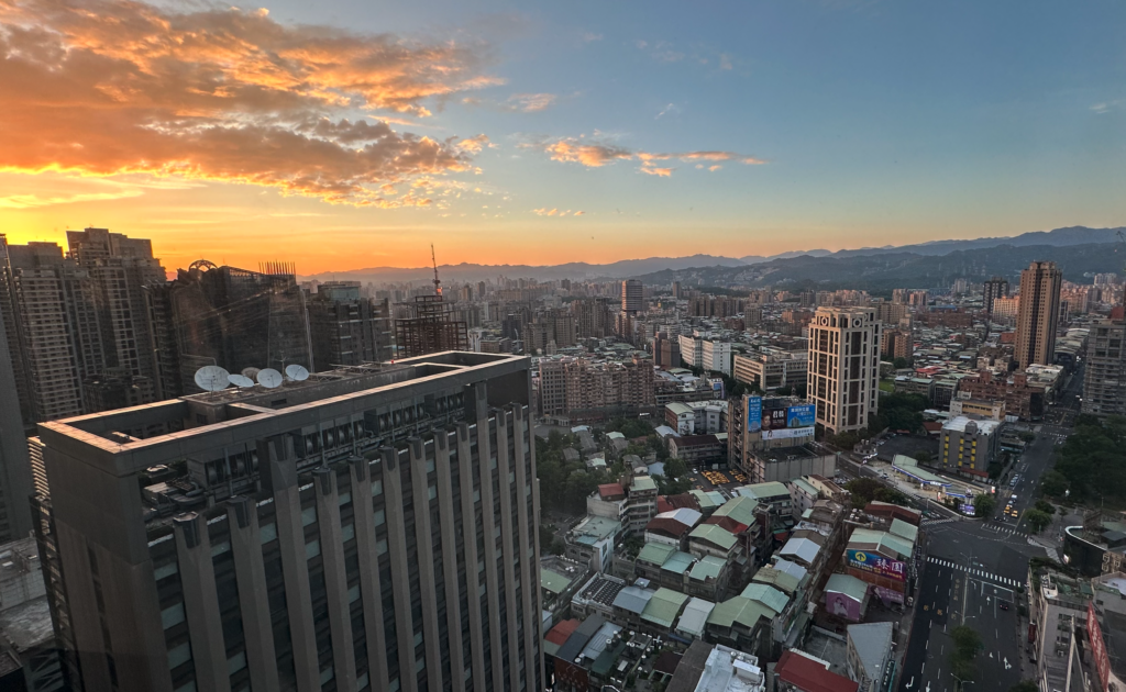 a cityscape with buildings and mountains in the background