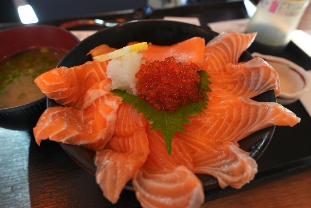 a bowl of raw fish with red caviar